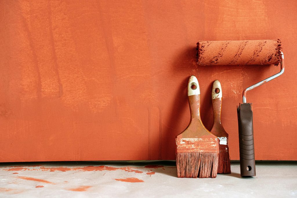 Interior painting tools on orange wall – Flowvations in Atlanta